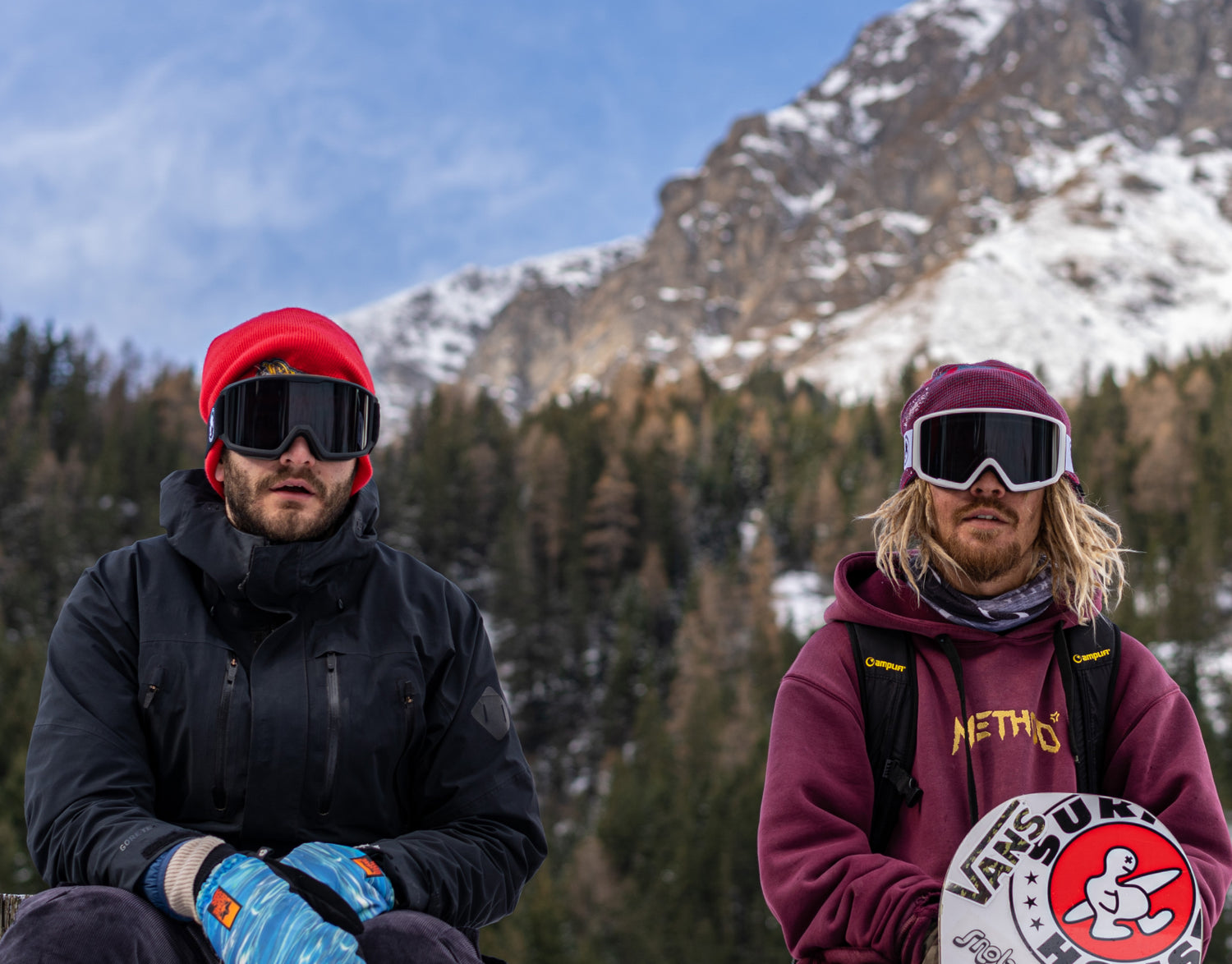 2 mens ambassadors from the bakedsnow snowboard goggles brand sitting in the mountains